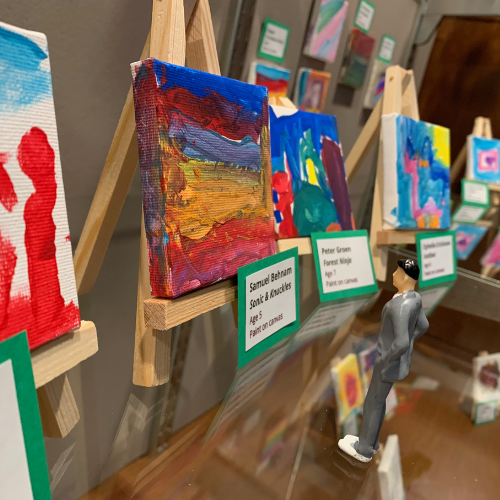 mini art show display with plastic toy man browsing